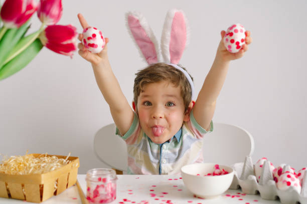 istock A little boy in bunny ears decorates Easter eggs. 1306307197