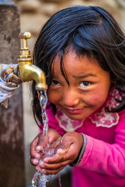 istock Nepalese girl drinking water, Upper Mustang, Nepal 1306309378