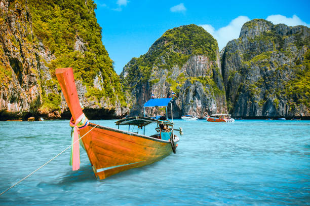 cortador de madera longboat amarrado en ko phi phi le island, tailandia - phuket province beach blue cliff fotografías e imágenes de stock