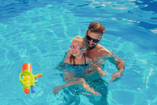 istock Father and daughter playing in the swimming pool 1306309675