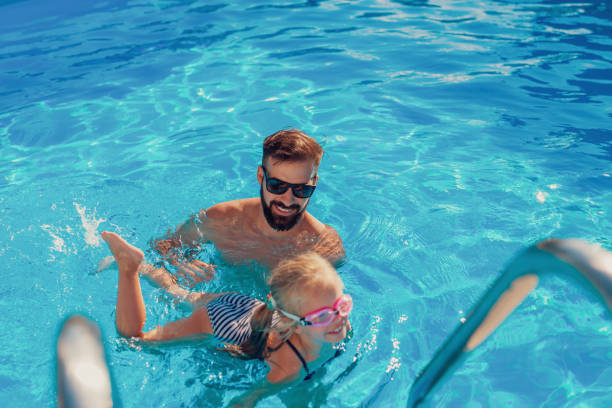 istock Father teaching daughter how to swim 1306309739