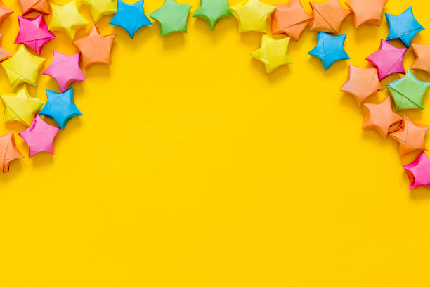 istock Colored paper stars. Yellow background. Place for your text or design. 1306311364
