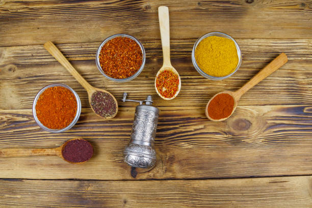 istock Set of different aromatic spices and spice mill on wooden table. Top view 1306311497