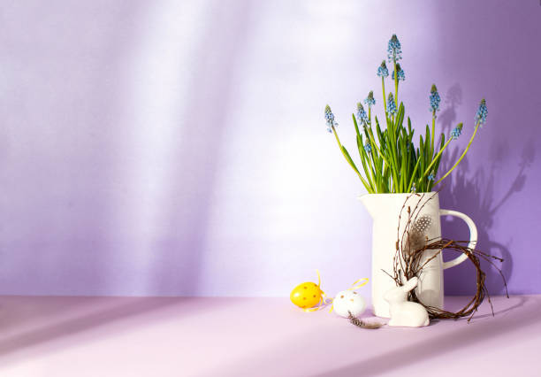 Sunny Easter home decor composition, front view of spring flowers, and white porcelain bunny, copy space for a greeting text