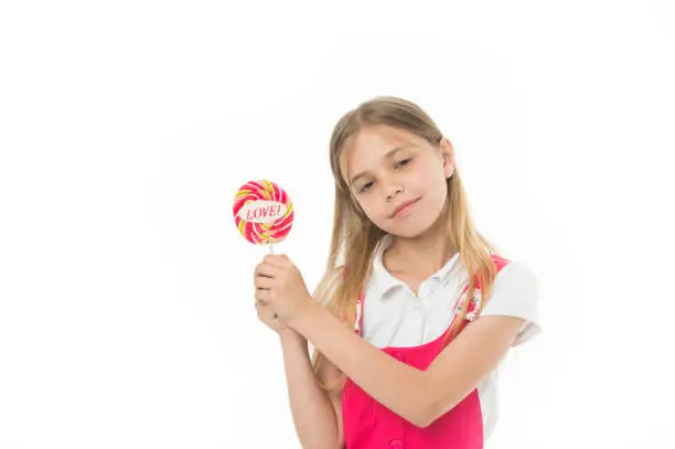 Girl with lollipop isolated on white. Little child hold candy with love lettering. Sweet beauty and look. Valentines day romance. Candyshop concept. Childhood and happiness. Sharing sweet love