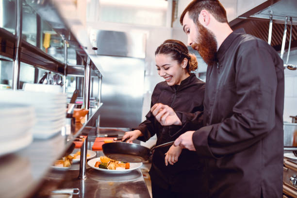 istock Modern Chef Checking Female Students Cooking Skills In Kitchen 1306312600