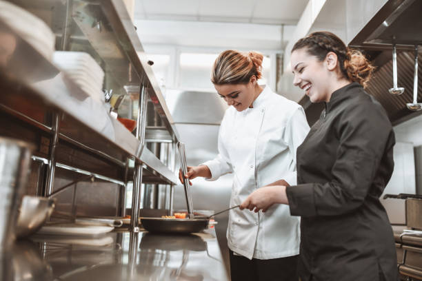 istock Smiling Female Cooks Competing While Cooking In Kitchen 1306312672