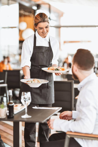 istock Smiling Waitress Happy On Her Job While Customers Get Good Food 1306312698