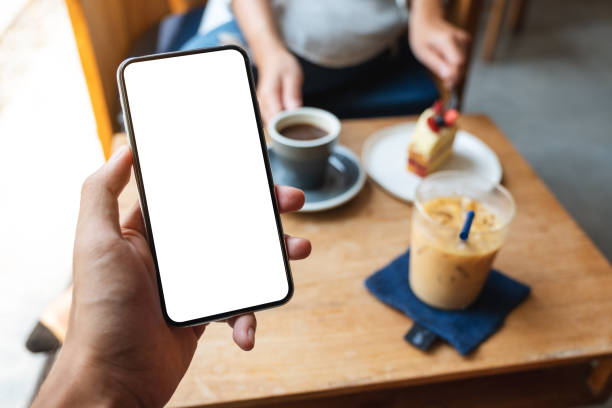 istock a man holding mobile phone with blank white screen in cafe 1306313070