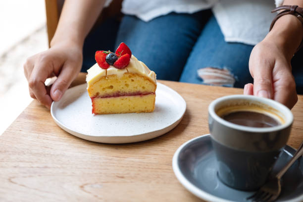 istock a woman holding a cake and coffee cup in cafe 1306313140