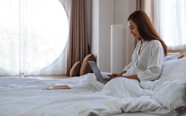 istock A woman using and working on laptop computer while lying on bed at home 1306313186