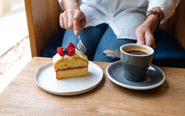 istock a woman eating cake and drinking coffee in cafe 1306313191