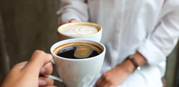 istock A man and woman clinking white coffee mugs in cafe 1306313216