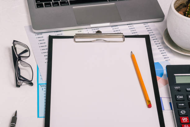 istock Blank sheet of paper for text on the desktop. Audit, analytics and banking. Research and analytics in business. Calculator, noctbook and charts 1306314371