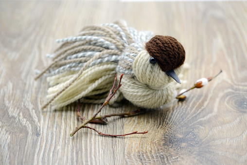 Sparrow yarn birds made of wool sit on a twig