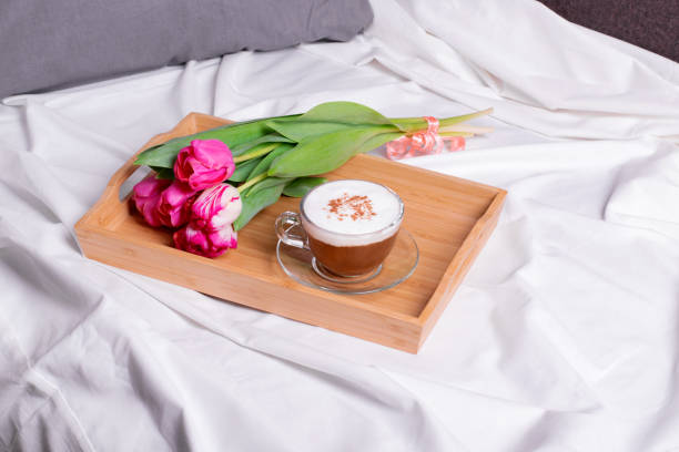 istock Coffee with cinnamon and pink tulips in bed 1306316554