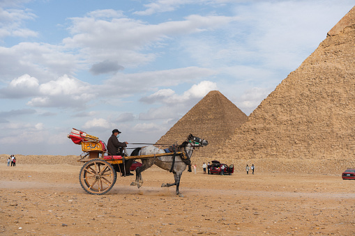 Cairo, Egypt - Dec. 2018: Tourists photographing themselfs with the Great Pyramids on the Giza Plateau