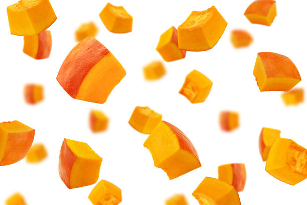 istock Falling piece of pumpkin, cubes, isolated on white background, selective focus 1306318392