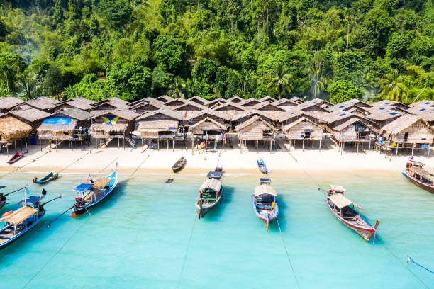 Aerial view of Ko Surin Marine National Park. Traditional long-tail boats and houses of Moken tribe Village or Sea Gypsies and tropical waters of Surin Islands in Thailand, Phang Nga. Aerial view of Ko Surin Marine National Park. Traditional long-tail boats and houses of Moken tribe Village or Sea Gypsies and tropical waters of Surin Islands in Thailand, Phang Nga. caiman stock pictures, royalty-free photos & images