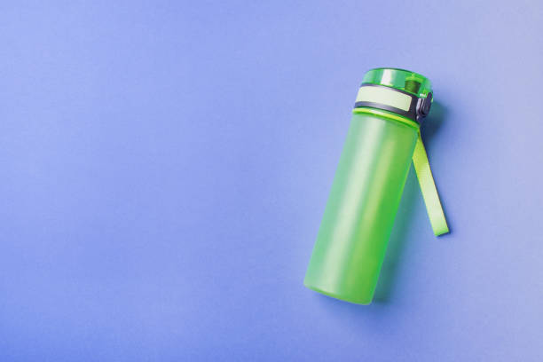 istock green plastic sport bottle lying on right side of blue background with copy space 1306319634