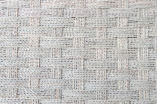 Close-up details textured shot of twisted white raffia cord basket weaving pattern background.
