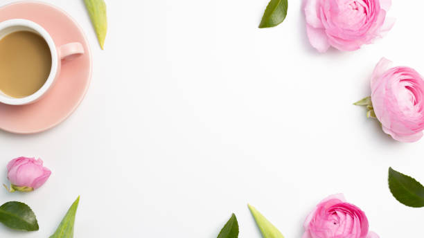 istock Cup of coffee and ranunculus flowers on white background. flat lay, top view, copy space 1306327852