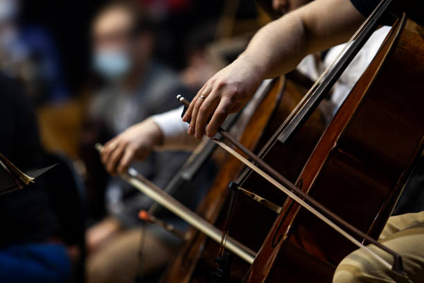 Hands of a musician playing cello in an orchestra