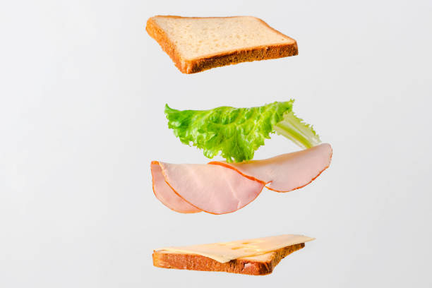 istock A sandwich with cheese and meat hangs in the air on a white background 1306335087