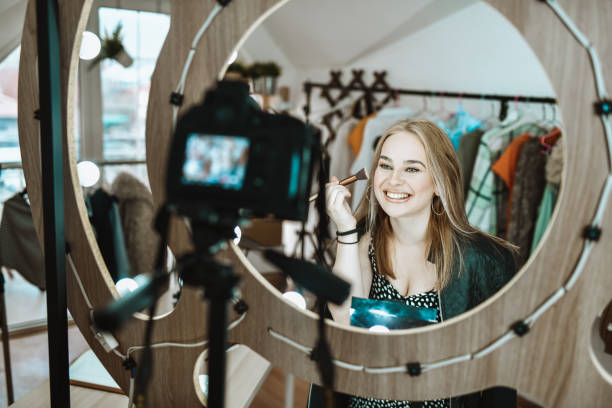 istock Smiling Female Teaching How To Use Makeup Brush In Vlog 1306335456