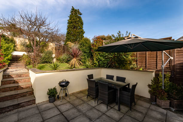 istock Paved back garden with seating, parasol and BBQ 1306338623