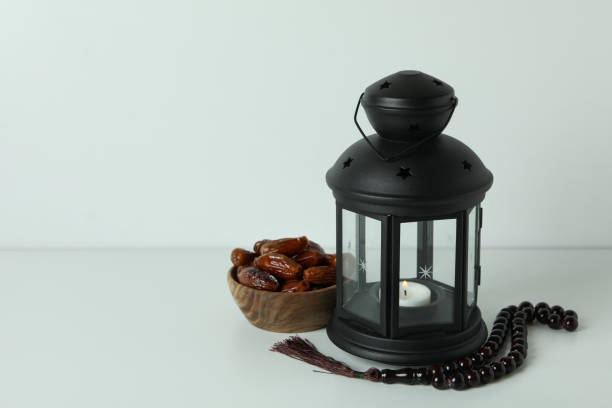 istock Lantern, rosary and bowl of dates on white background 1306340520