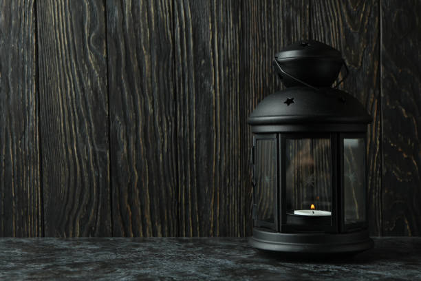 istock Black lantern against wooden background, space for text 1306341338