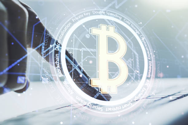 istock Double exposure of creative Bitcoin symbol with hands typing on laptop on background. Cryptocurrency concept 1306342112