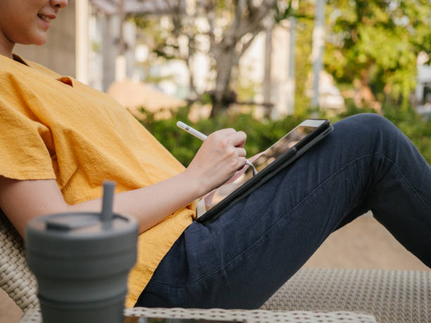 Freelancer working with digital tablet and digitized pen outdoor.