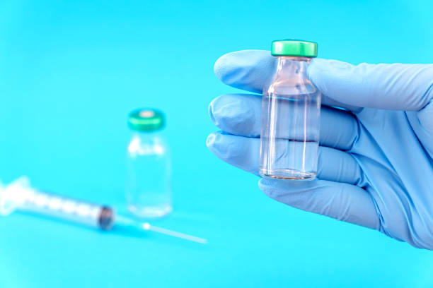 istock Potential trials stage concept on blue background. Close up Vials with sterile needle syringe. Research and Development, Vaccination 1306344421