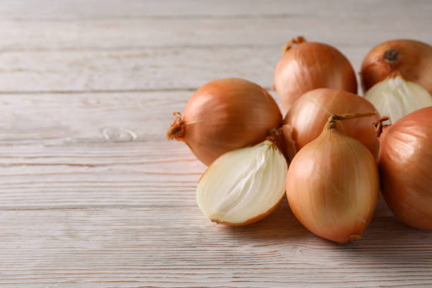 istock Ripe fresh onion on wooden background, space for text 1306344545