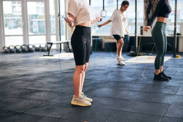 istock Slender young women skipping with ropes at gym 1306347371