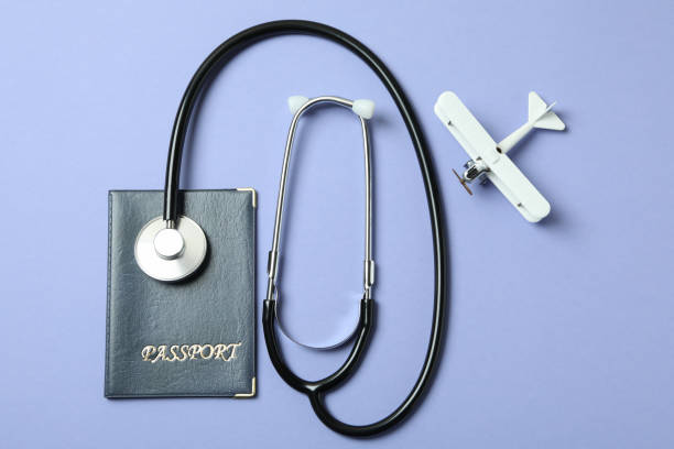 istock Passport, stethoscope and toy plane on violet background 1306347715