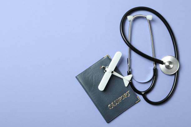 istock Passport, stethoscope and toy plane on violet background 1306347823