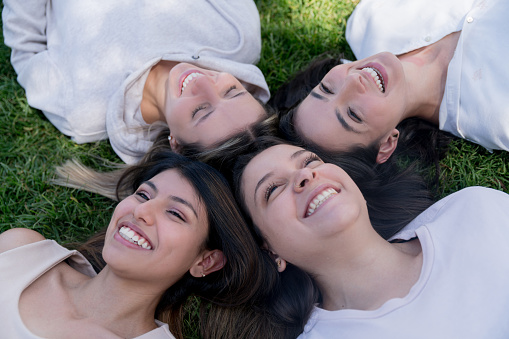 Happy group of Latin American women smiling while relaxing at the park - lifestyle concepts