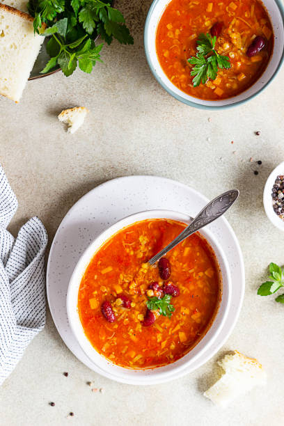 gorąca i pikantna, gęsta zupa z soczewicy i czerwonej fasoli z pomidorami w puszkach i kolendrą. betonowe tło. widok z góry. - lentil dinner holiday mediterranean cuisine zdjęcia i obrazy z banku zdjęć