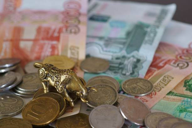 istock Metal bull with coins and banknotes on the table. 1306349687