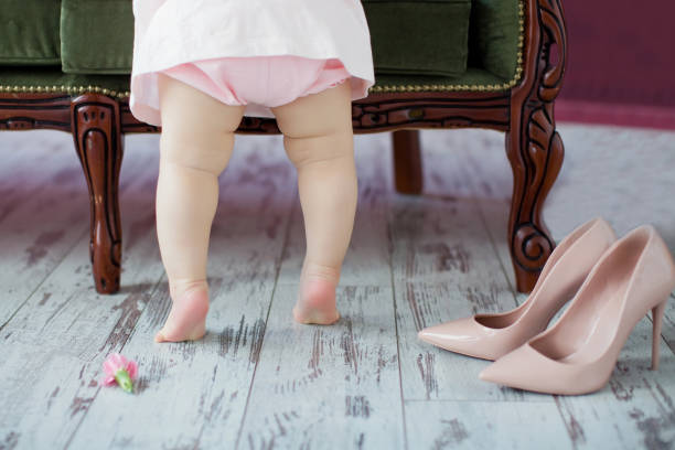 istock Little baby's legs and woman's shoes 1306350241