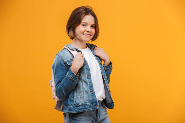 Verticale d’une petite écolière de sourire avec le sac à dos - Photo