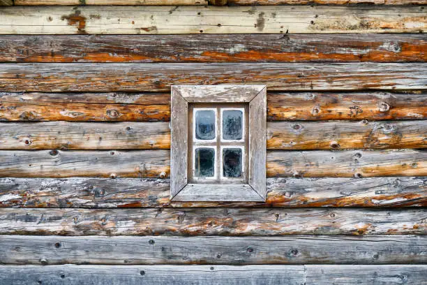 Log house wall with a small window in the middle