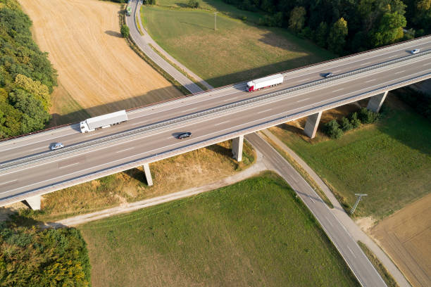 istock Trucks on Highway Bridge, Aerial View 1306354110