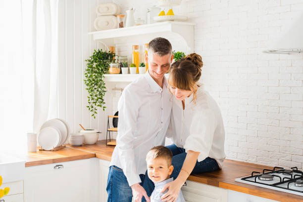 istock Young happy parents with a baby in the kitchen 1306354317