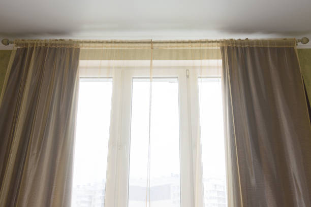 istock Curtains and tulle curtains large plastic windows in the apartment, close-up 1306354347