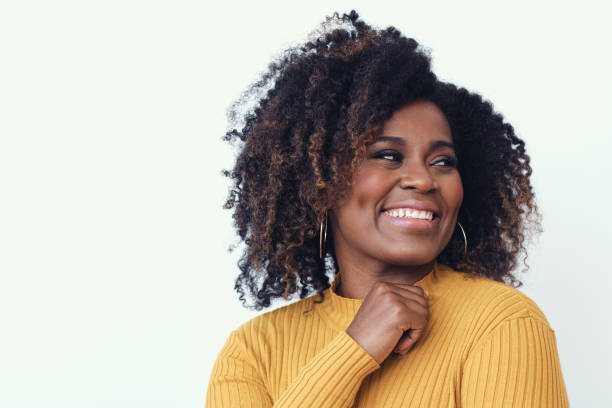 Portrait of a happy young woman smiling Portrait of a happy young woman smiling dressed in a yellow shirt, looking right natural hair stock pictures, royalty-free photos & images