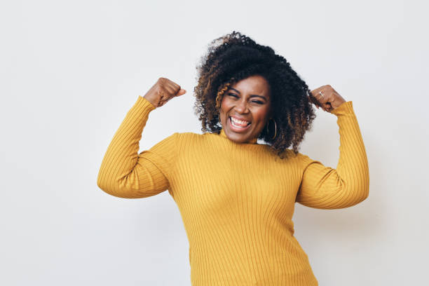 cheerful strong woman flexing muscles against white background - flexing muscles fotos imagens e fotografias de stock